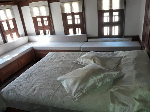 a bed with pillows in a room with windows at Çamlıca Konak Çarsı in Safranbolu