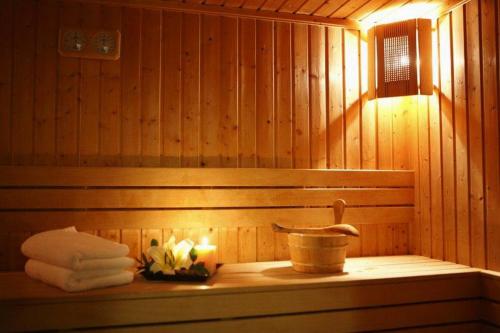 a sauna with a candle and towels on a table at Hotel Troya in Kostroma