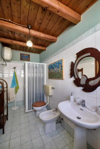 a bathroom with a sink and a toilet and a mirror at Le Terrazze di Angela in Marina di Ragusa
