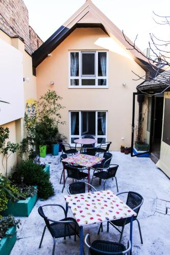 a patio with tables and chairs in front of a building at Varad INN in Novi Sad