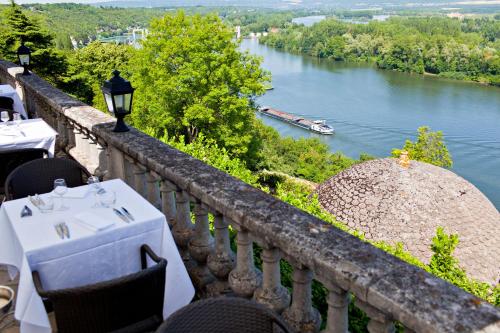 a balcony with a table and a view of a river at Domaine De La Corniche in Rolleboise