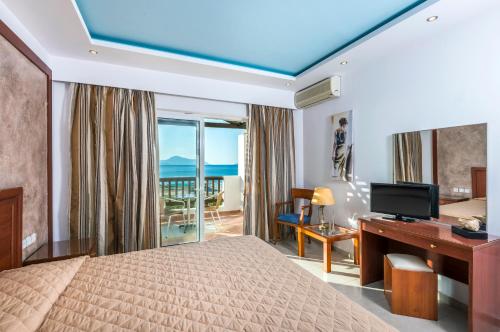 a bedroom with a bed and a desk with a computer at Gaia Royal in Mastichari