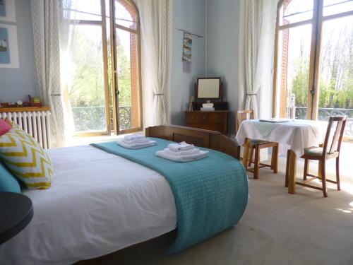 a bedroom with a bed with a table and chairs at La Maison Du Marchand in Peyrat-le-Château