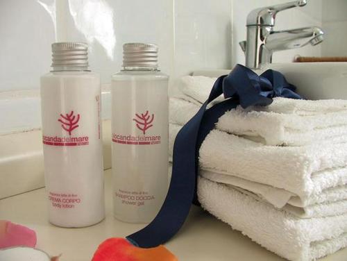 two bottles of shampoo and towels on a bathroom counter at La Locanda Del Mare in Paestum
