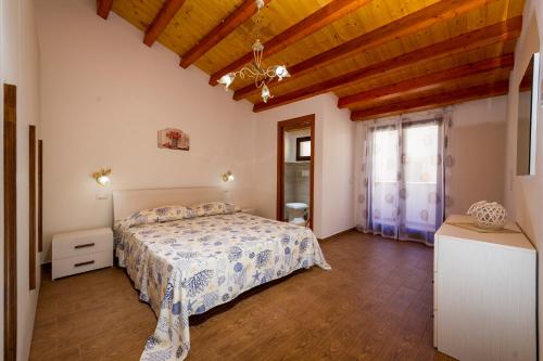 a bedroom with a bed and a wooden ceiling at Il Glicine Appartamenti & Rooms in Castellammare del Golfo