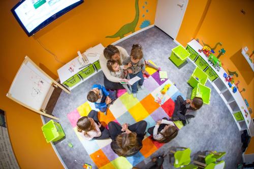 a group of children sitting around a table in a room at Domaine De La Corniche in Rolleboise