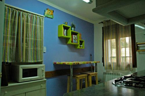 eine Küche mit einer Mikrowelle und einer blauen Wand in der Unterkunft Casa Lugaré in Ayerbe