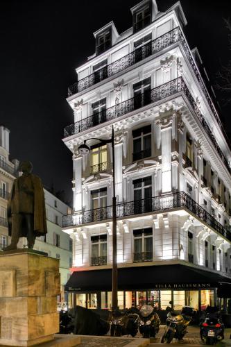 a large white building with a statue in front of it at La Villa Haussmann in Paris