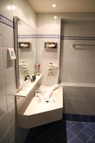 a bathroom with two sinks and a mirror at Andi's Skihotel in Obertauern