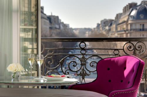 a table with a pink chair and a table with a plate of food at La Villa Haussmann in Paris