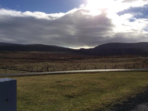 a view of a field with mountains in the background at The Homer in Kilmuir