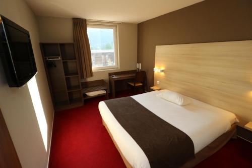 a hotel room with a bed and a television at Ekho Hotel Grenoble Nord Saint Egrève in Saint-Égrève