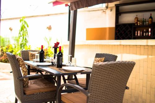 a wooden table with chairs and bottles of wine at The Jam Lodge in Freetown