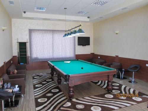 una sala de billar con mesa de billar y sillas en Dian Hotel, en Kapan