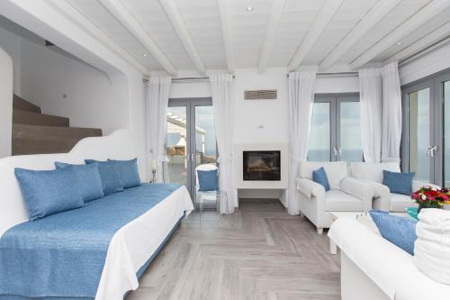 a white bedroom with blue and white furniture and a fireplace at Naxos Rock Villas in Stelida