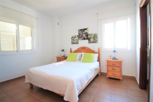 a bedroom with a bed and a dresser and two windows at Villa Sofia in San Antonio