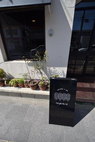 a sign on the sidewalk in front of a building at Saga International Guesthouse Hagakure in Saga