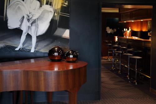 a room with a table and a bed and a bar at Domaine De La Corniche in Rolleboise