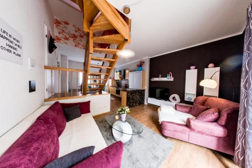 ein Wohnzimmer mit rosa Möbeln und einer Treppe in der Unterkunft harz-traum in Gernrode - Harz