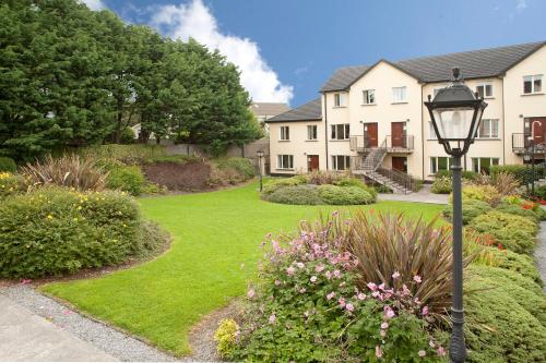 a house with a yard with a street light and flowers at Menlo Park Apartments in Galway