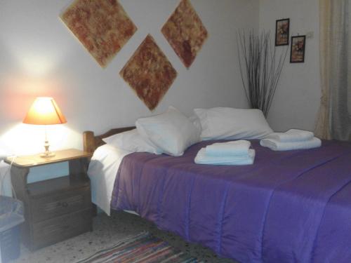 a bedroom with a bed with two towels on it at Captain's Rooms in Aegina Town