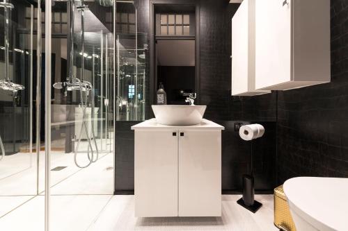 La salle de bains est pourvue d'un lavabo blanc et d'une douche. dans l'établissement Deco Gem Aliados, à Porto