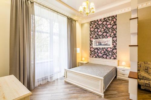 ein Schlafzimmer mit einem Bett und einem großen Fenster in der Unterkunft VIP Apartments in Lwiw
