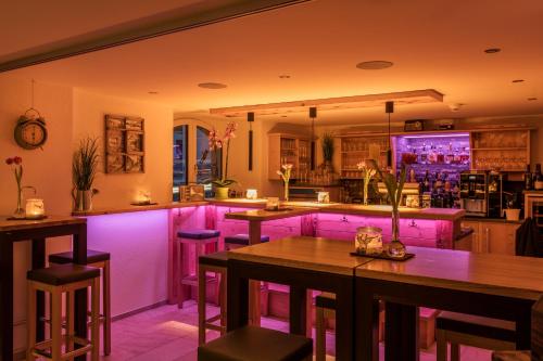 a bar with pink lighting in a restaurant at Hotel Krone in Schruns-Tschagguns