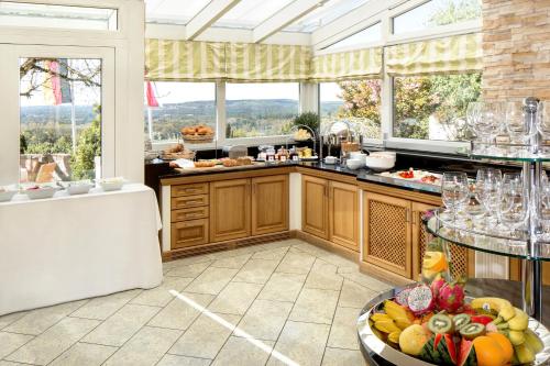 una cocina con mesa y un bol de fruta en Hotel-Restaurant Distlerhof, en Leinburg