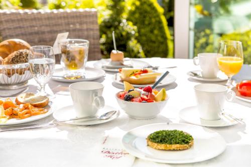 Una mesa cubierta con platos de comida y bebidas. en Hotel-Restaurant Distlerhof, en Leinburg