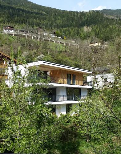 a building on a hill with trees at Haus am Stein in Oetz