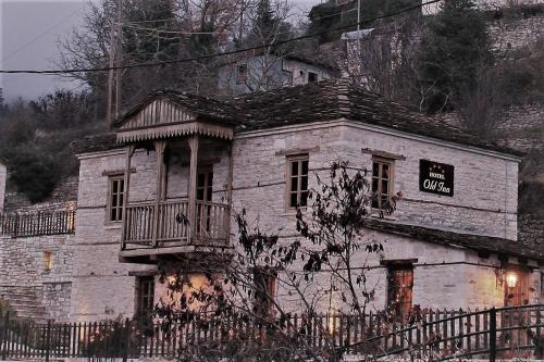 an old stone building with a balcony on it at Old Inn in Karpenision