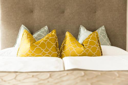 a group of pillows sitting on top of a bed at Hotel Burggräflerhof in Merano