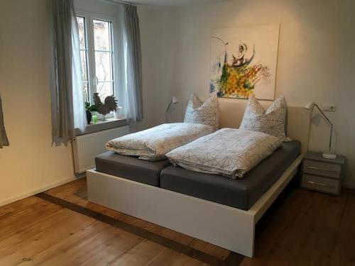 een bed met kussens in een kamer bij Unterm Blauregen in Wangen