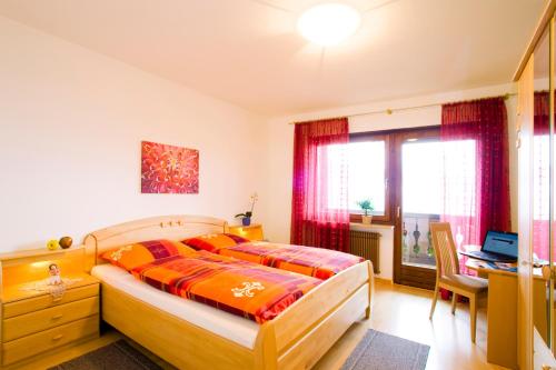 um quarto com uma cama, uma secretária e uma janela em Appartements Peilerhof em Cermes