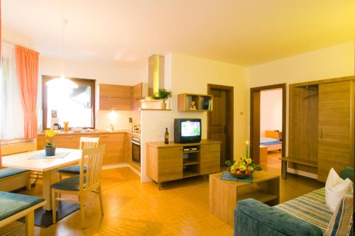 Appartements Peilerhof في سيرميس: غرفة معيشة مع مطبخ وغرفة طعام