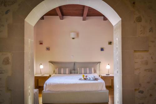 a bedroom with a bed and two tables with lamps at Veneto Boutique Hotel in Rethymno Town