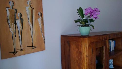 a vase of flowers on a table next to a painting at Apartment mit Gartenblick in Forchheim
