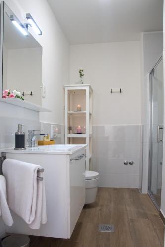 a white bathroom with a sink and a toilet at Apartments Bego Spa & Wellness in Crikvenica