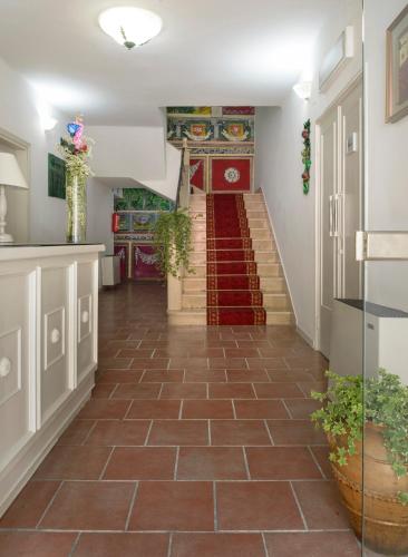 a hallway with a tile floor and stairs at Hotel Porta Marmorea in Gubbio