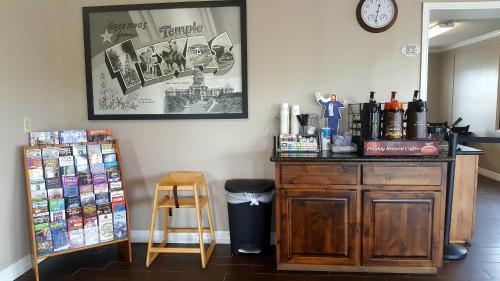 a room with a counter with a table and a clock at Super 8 by Wyndham Temple S General Bruce in Temple