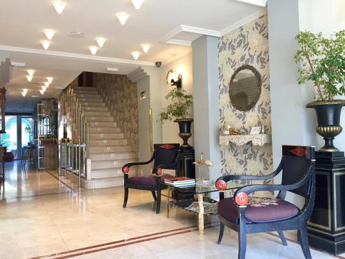 un vestíbulo con sillas, una mesa y una escalera en Hotel Maria Luisa, en Burgos