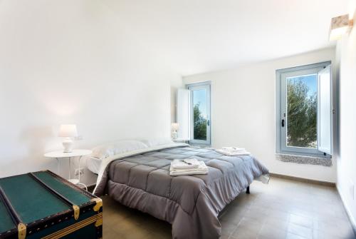 オルビアにあるAgriturismo Cabu Abbasの白いベッドルーム(ベッド1台、窓2つ付)