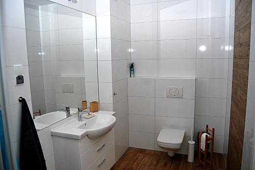 コウォブジェクにあるApartament Solna Kołobrzegの白いバスルーム(洗面台、トイレ付)
