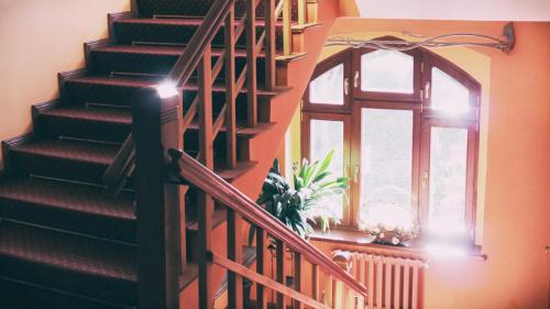 a staircase with a window and a potted plant at Pensjonat Eldorado in Świeradów-Zdrój