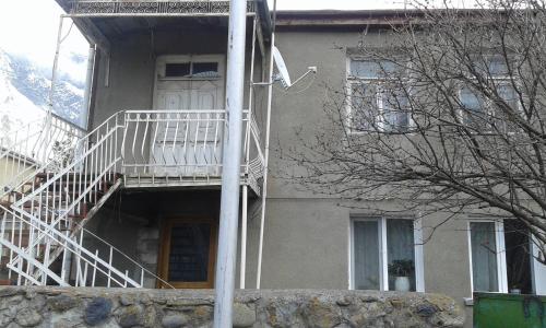 a house with a staircase in front of a building at Guest House Dodo in Stepantsminda