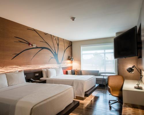 a hotel room with two beds and a tv at Cambria Hotel McAllen Convention Center in McAllen