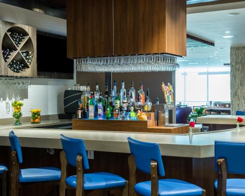 a bar in a restaurant with blue chairs at Cambria Hotel McAllen Convention Center in McAllen