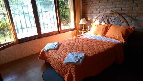a bedroom with a large bed in a room with windows at Hosteria Cumilinche in Same