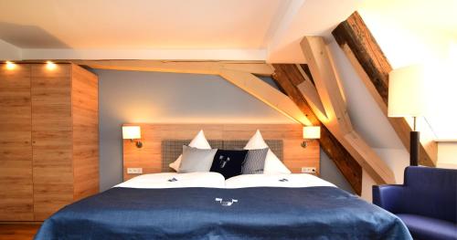 a bedroom with a large bed with a blue blanket at Hotel Alte Vogtei in Wolframs-Eschenbach